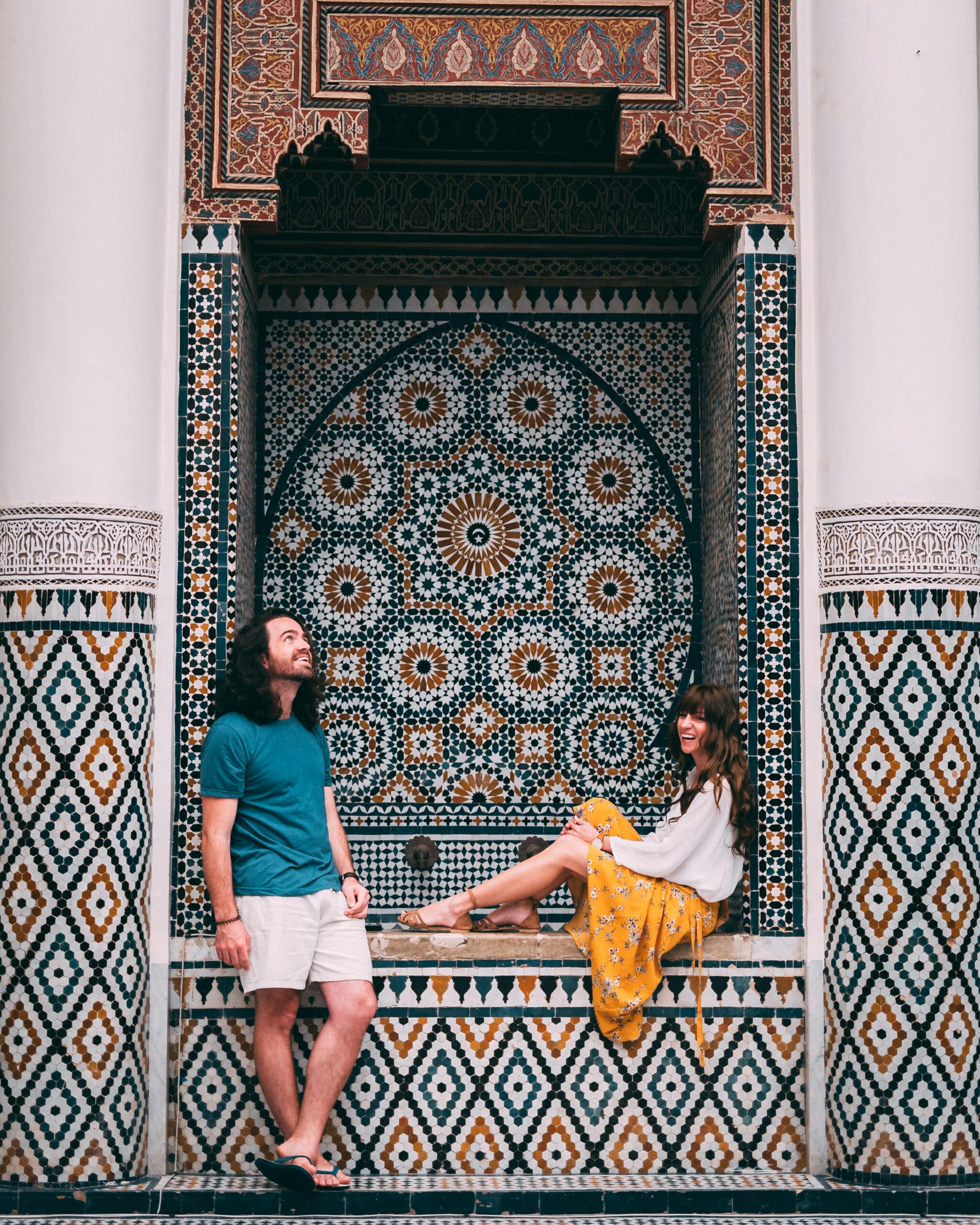 A couple posing by vibrant Moroccan mosaic tiles in Marrakesh. Ideal for travel and culture themes.